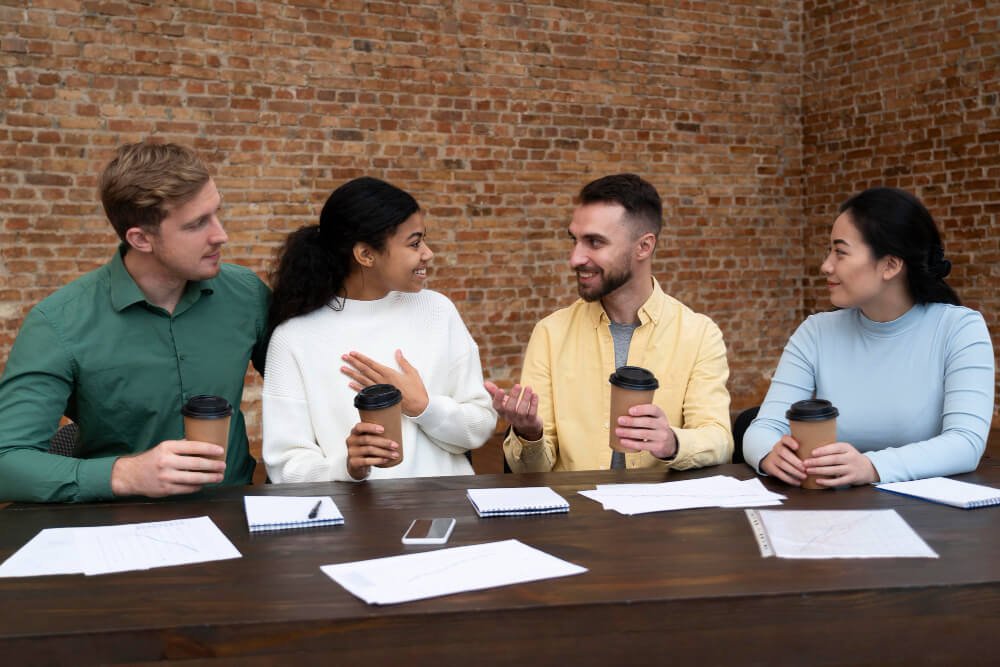 Diverse team reviewing financial documents and charts over coffee