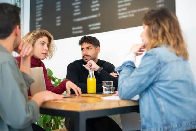 Four professionals in a collaborative HR and business strategy meeting