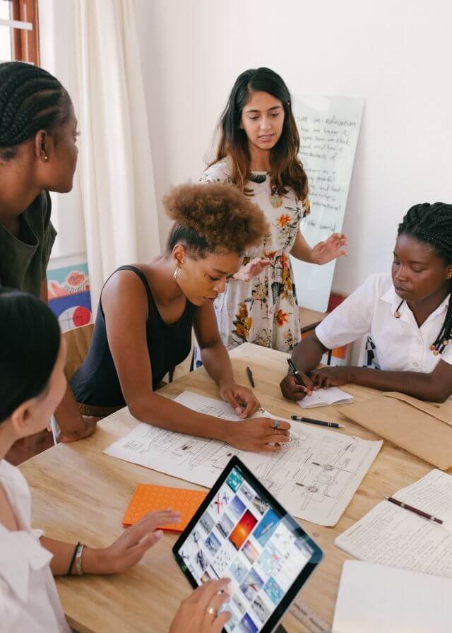 Diverse team of women collaborating on project plans in a bright office